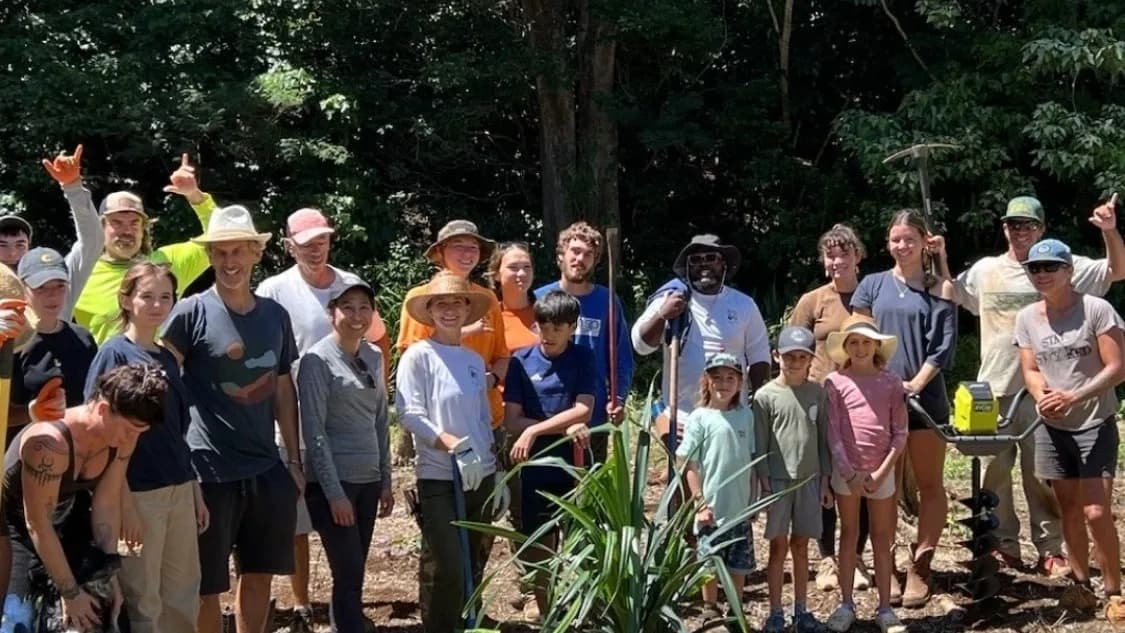 Diverse group of student and community volunteers at an outdoor planting event